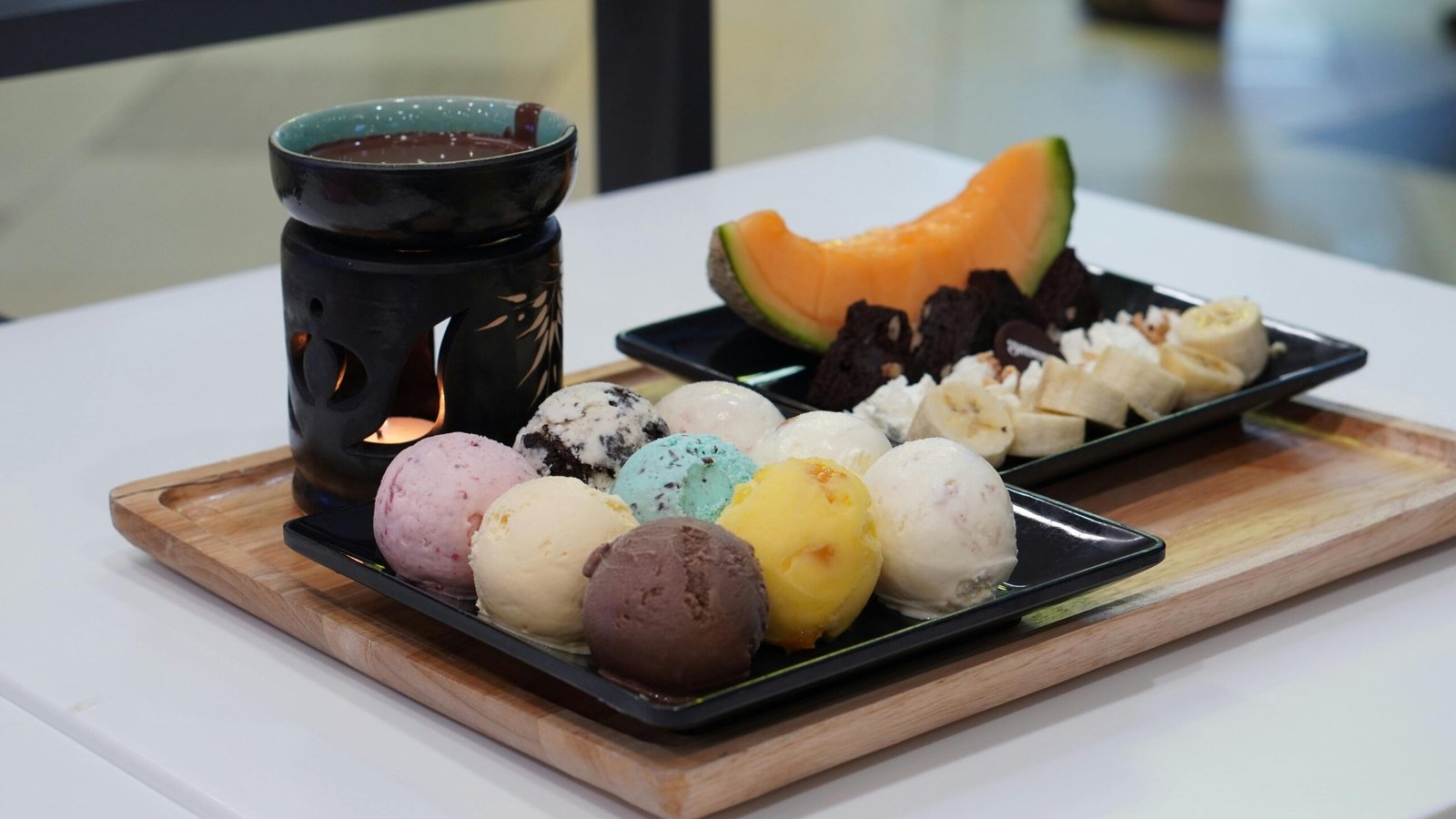 A vibrant dessert platter featuring assorted ice cream, fruits, and hot chocolate for a delightful treat.