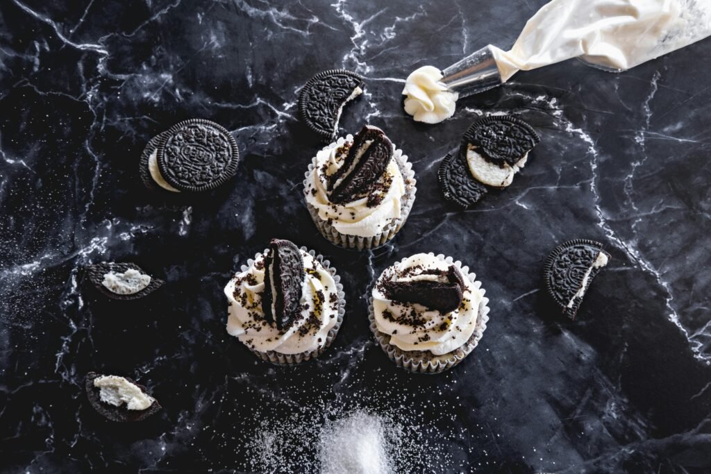 Delicious Oreo-topped cupcakes on a stylish marble background with cookies and frosting elements.